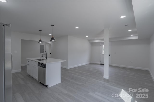 kitchen with light countertops, stainless steel appliances, light wood-style floors, a sink, and recessed lighting