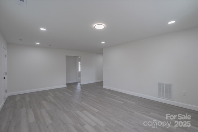 spare room with baseboards, visible vents, wood finished floors, and recessed lighting