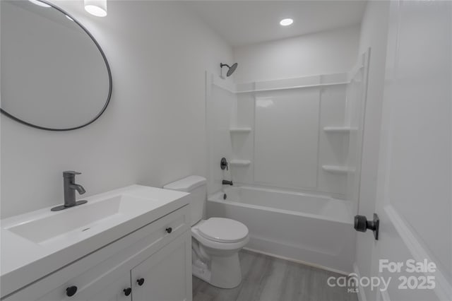 bathroom featuring toilet, bathtub / shower combination, wood finished floors, and vanity