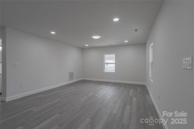 empty room featuring recessed lighting, wood finished floors, visible vents, and baseboards