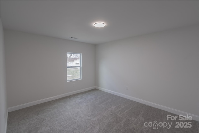 carpeted empty room featuring visible vents and baseboards