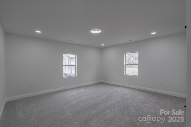 carpeted spare room featuring baseboards and recessed lighting