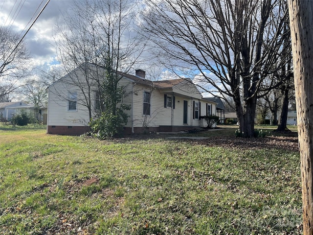 view of property exterior featuring crawl space, a chimney, and a lawn