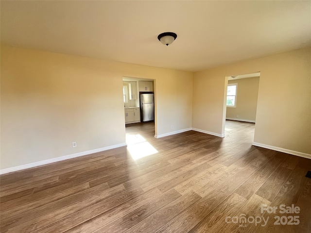 unfurnished room featuring wood finished floors and baseboards