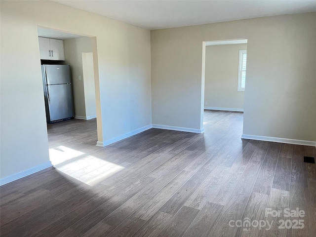 unfurnished room featuring dark wood finished floors and baseboards