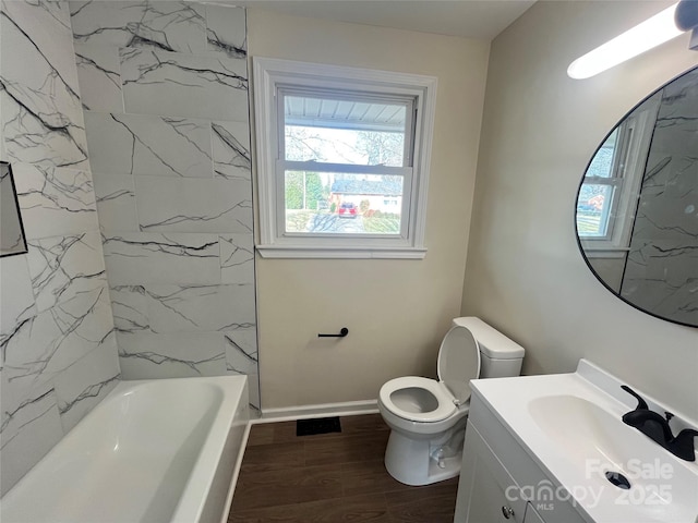 bathroom with toilet, vanity, wood finished floors, and a wealth of natural light