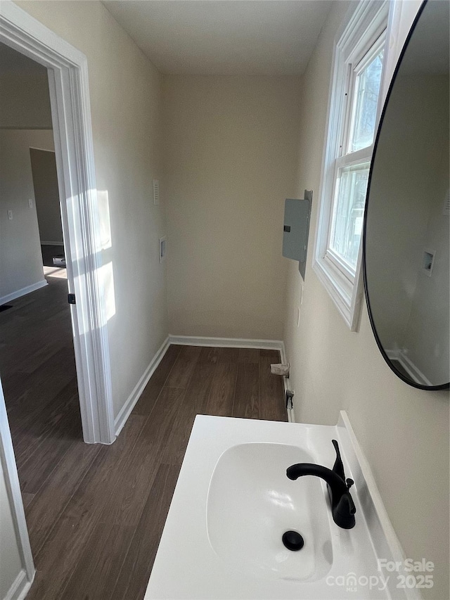 bathroom featuring a sink, baseboards, and wood finished floors