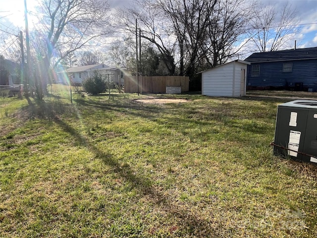 view of yard featuring a storage unit, fence, cooling unit, and an outdoor structure