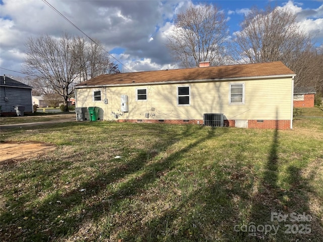 back of house featuring a yard, crawl space, a chimney, and cooling unit