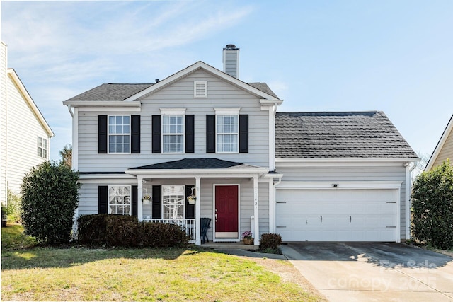 traditional-style home featuring a chimney, a porch, concrete driveway, an attached garage, and a front lawn