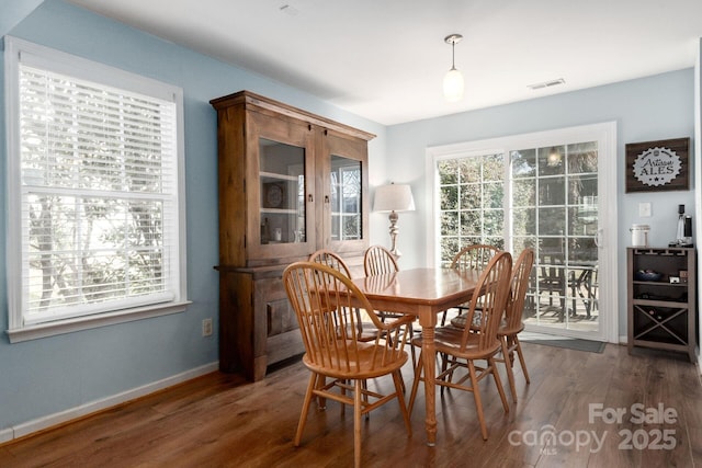 dining room with visible vents, baseboards, and wood finished floors