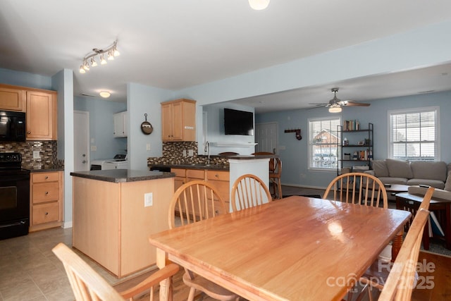 dining room featuring washer / dryer, ceiling fan, light tile patterned floors, and baseboards