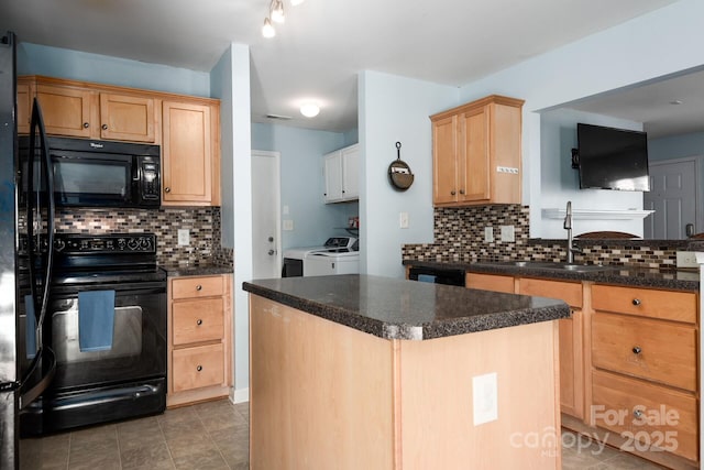 kitchen featuring dark countertops, black appliances, tasteful backsplash, and washer and dryer