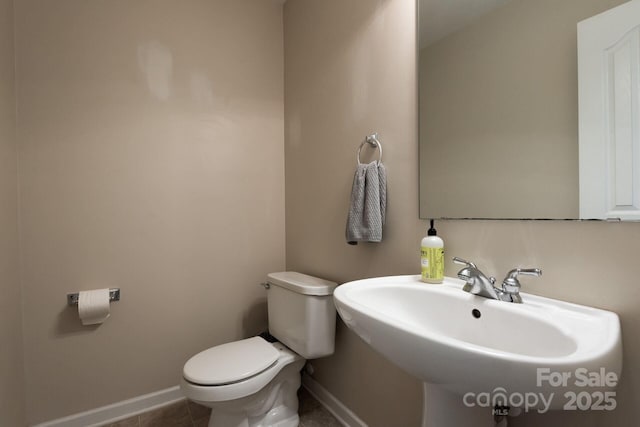 bathroom featuring tile patterned flooring, baseboards, a sink, and toilet