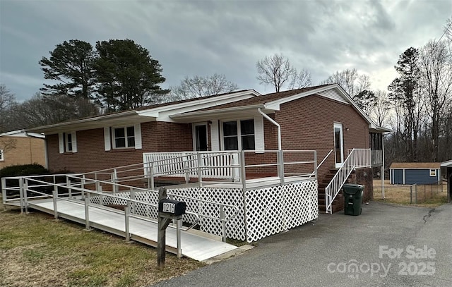 single story home featuring covered porch and brick siding