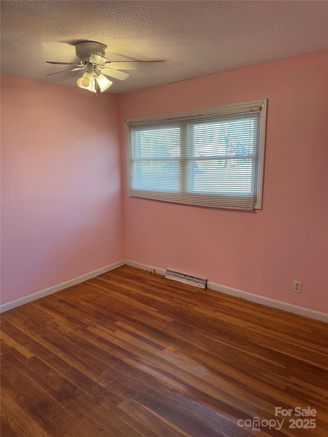 unfurnished room with ceiling fan, baseboards, a textured ceiling, and wood finished floors