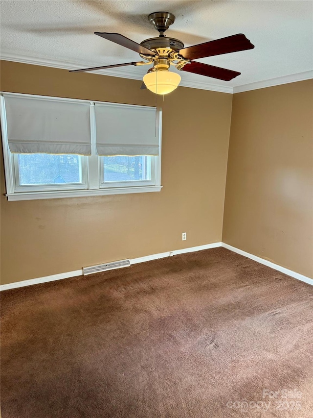 carpeted spare room featuring baseboards, visible vents, ceiling fan, a textured ceiling, and crown molding