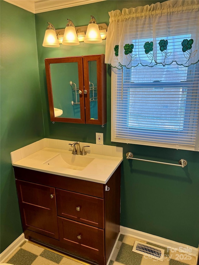 bathroom with baseboards, visible vents, and vanity