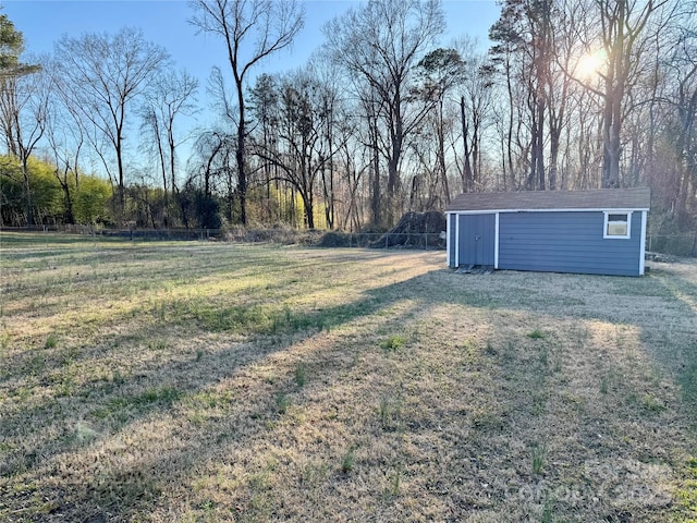 view of yard featuring an outbuilding, fence, and a storage unit