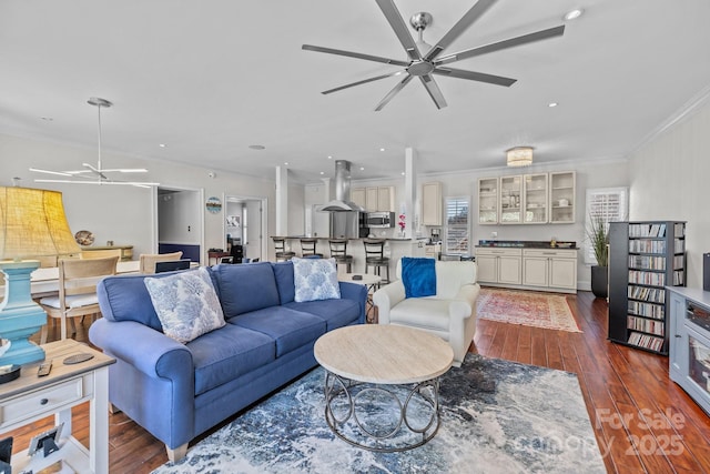 living room with ceiling fan, dark wood finished floors, and crown molding