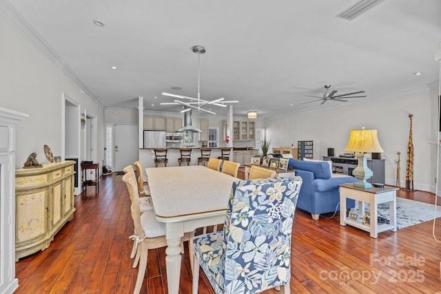 dining area featuring ornamental molding, visible vents, and hardwood / wood-style floors