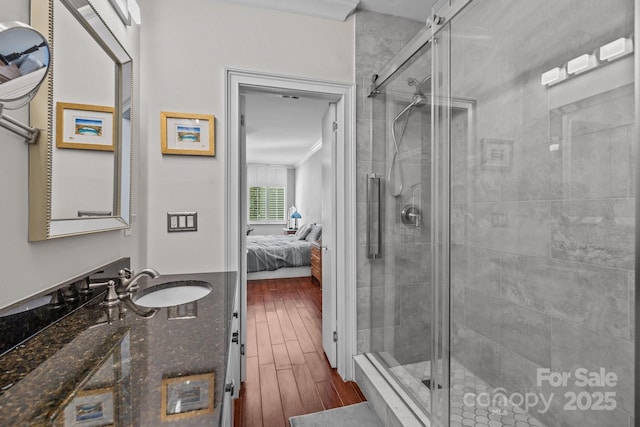 full bathroom featuring vanity, a shower stall, ensuite bathroom, and wood finished floors