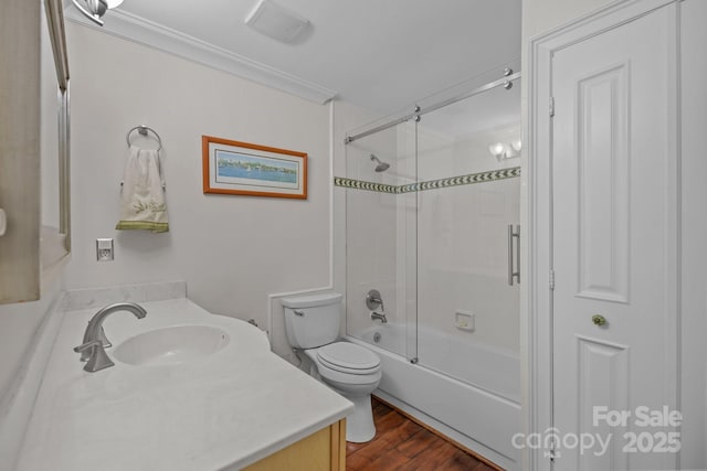 bathroom with visible vents, bath / shower combo with glass door, toilet, wood finished floors, and vanity