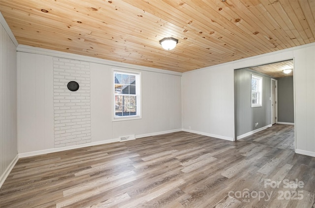 spare room featuring visible vents, baseboards, wood ceiling, and wood finished floors