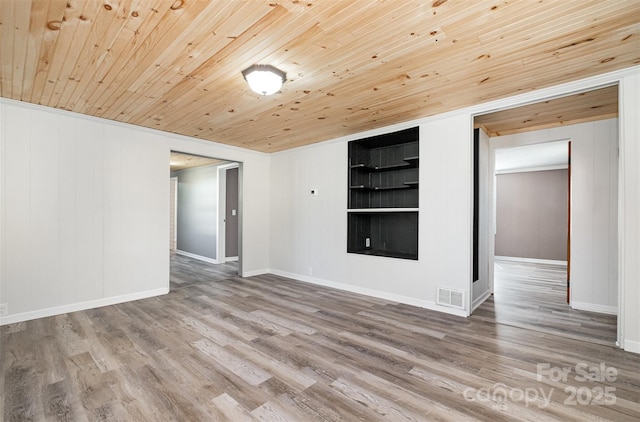 spare room featuring visible vents, baseboards, wood ceiling, and wood finished floors