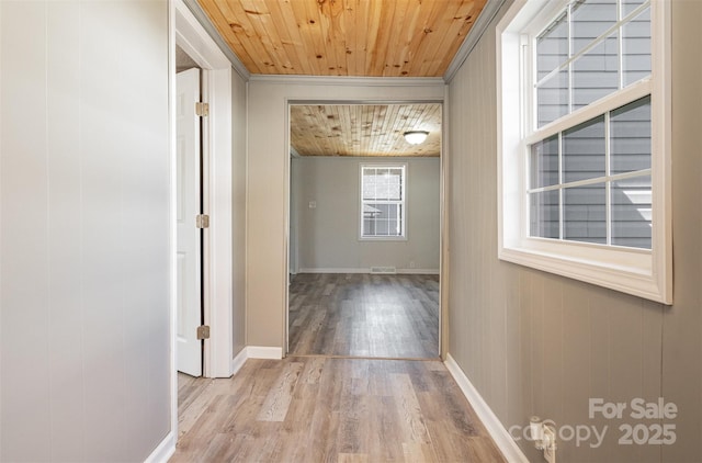 hallway featuring wooden ceiling, baseboards, and wood finished floors