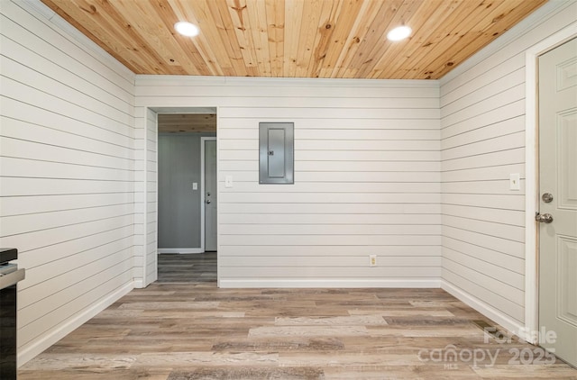 empty room with electric panel, recessed lighting, wooden ceiling, and light wood-style floors