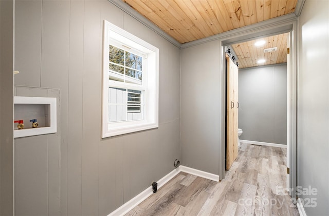 washroom with baseboards, wood ceiling, light wood-type flooring, washer hookup, and laundry area