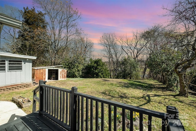 deck with a yard, an outbuilding, a storage shed, and fence