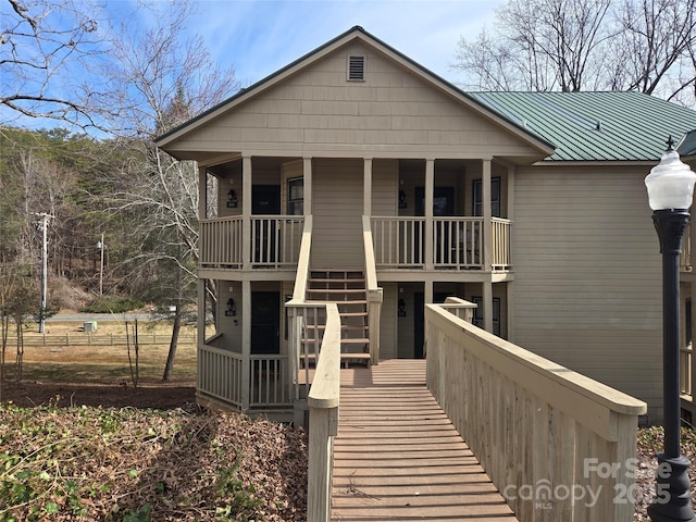 view of front of property with a porch, a standing seam roof, metal roof, and stairs