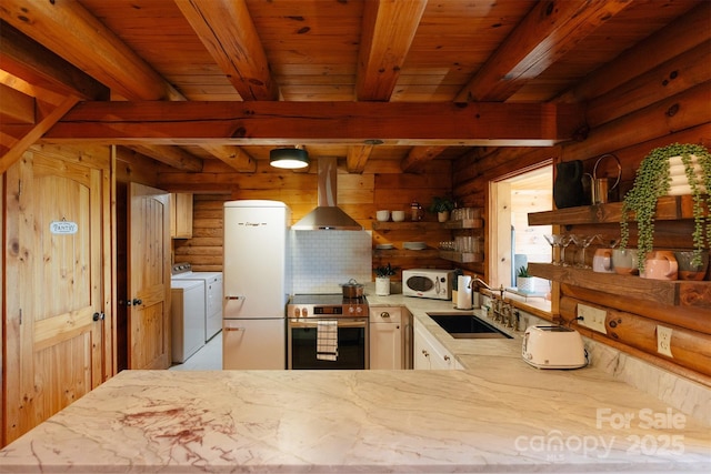 kitchen with a sink, washer and dryer, white appliances, a peninsula, and exhaust hood