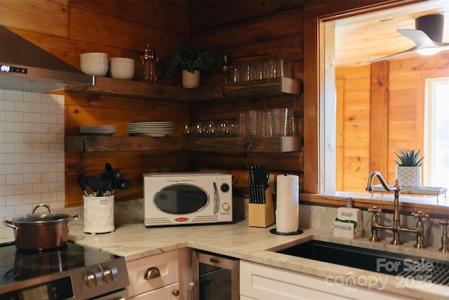 kitchen with stainless steel electric range oven, wine cooler, under cabinet range hood, white cabinetry, and a sink