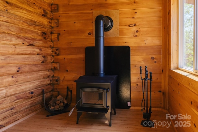 details with wood finished floors, a wood stove, and wooden walls