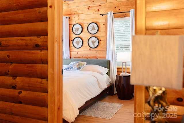 bedroom with wooden walls and wood finished floors