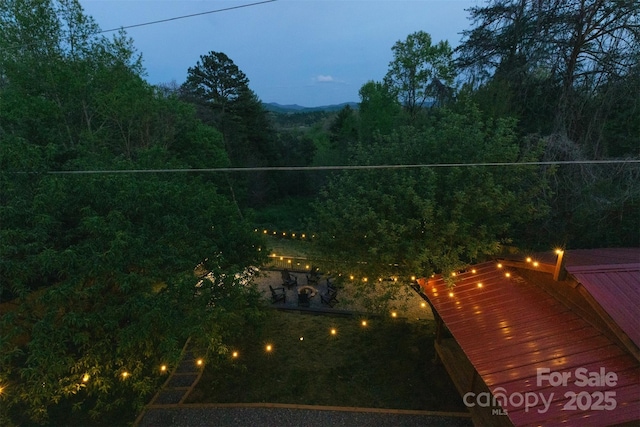 view of yard featuring a deck and a view of trees