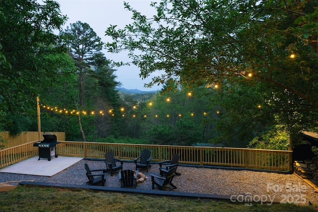 exterior space featuring an outdoor fire pit, area for grilling, and fence