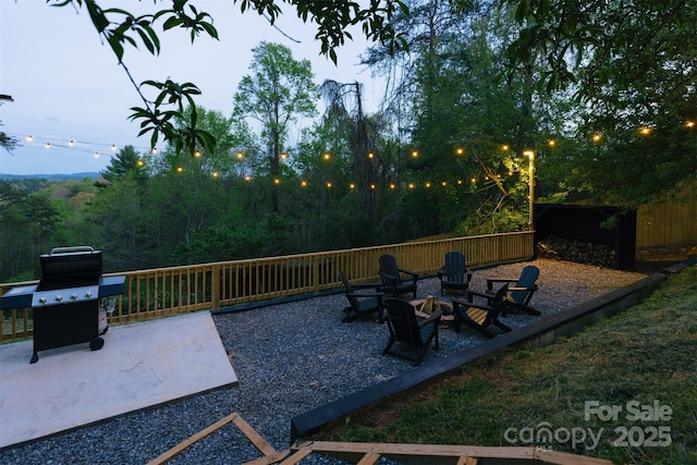 view of patio with an outdoor fire pit, grilling area, and fence