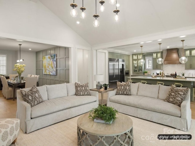 living room with light wood-style floors, high vaulted ceiling, and recessed lighting