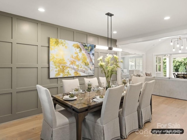 dining space with lofted ceiling, a decorative wall, light wood-style flooring, and recessed lighting