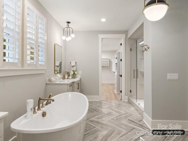 full bath featuring a freestanding tub, a shower stall, baseboards, and vanity