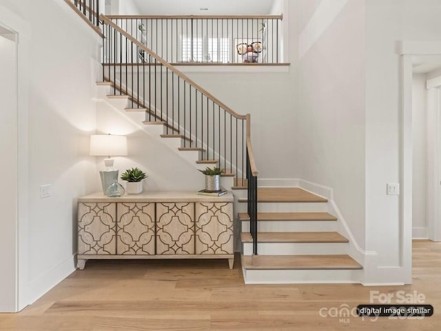 stairway with baseboards and wood finished floors