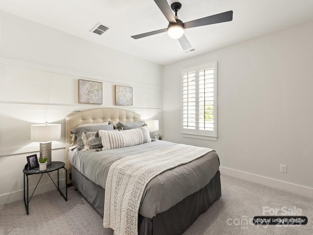 bedroom featuring baseboards, a ceiling fan, visible vents, and light colored carpet