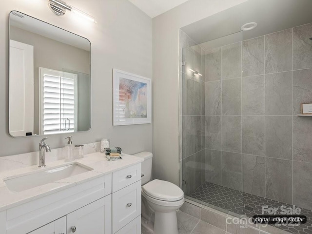 full bath with vanity, a shower stall, and toilet