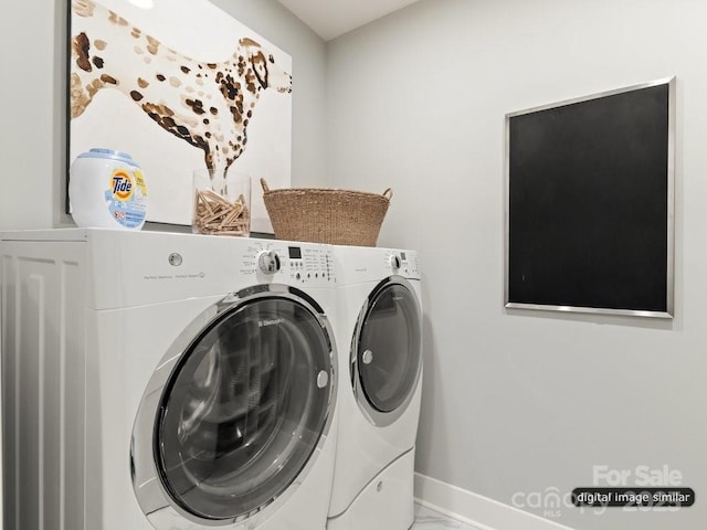 laundry room featuring laundry area, baseboards, marble finish floor, and washer and clothes dryer