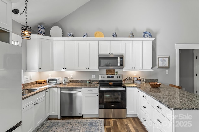 kitchen featuring stainless steel appliances, white cabinets, and a peninsula