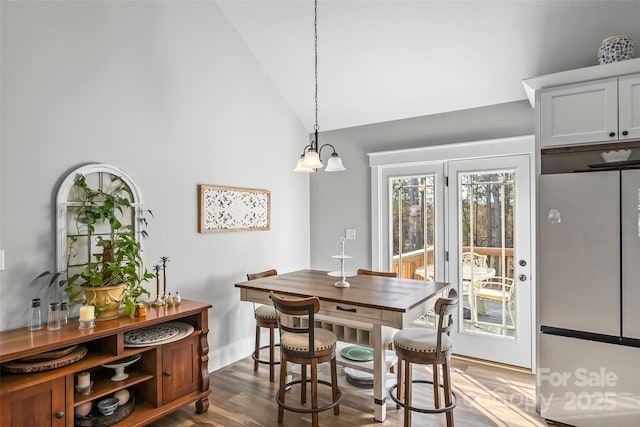 dining room featuring lofted ceiling and dark wood finished floors